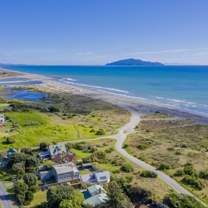 Overhead view of West Maui coastline with waves, residential homes, and lush scenery — featured in the West Maui Travel Guide 2025