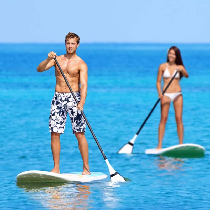 Couple stand up paddleboarding on clear turquoise ocean water under sunny skies, representing the Best Places to Paddleboard in Maui for adventure and relaxation.