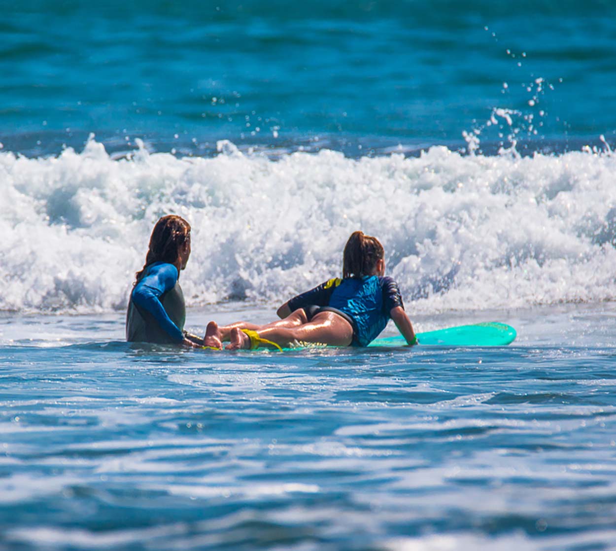 man-surfing-on-maui-ocean-nd instructor-guide-the girl