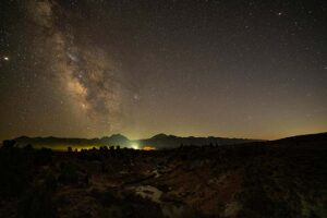A brilliant Stargaze in Remote Areas illuminates the mountain range, casting a serene glow over the landscape at night